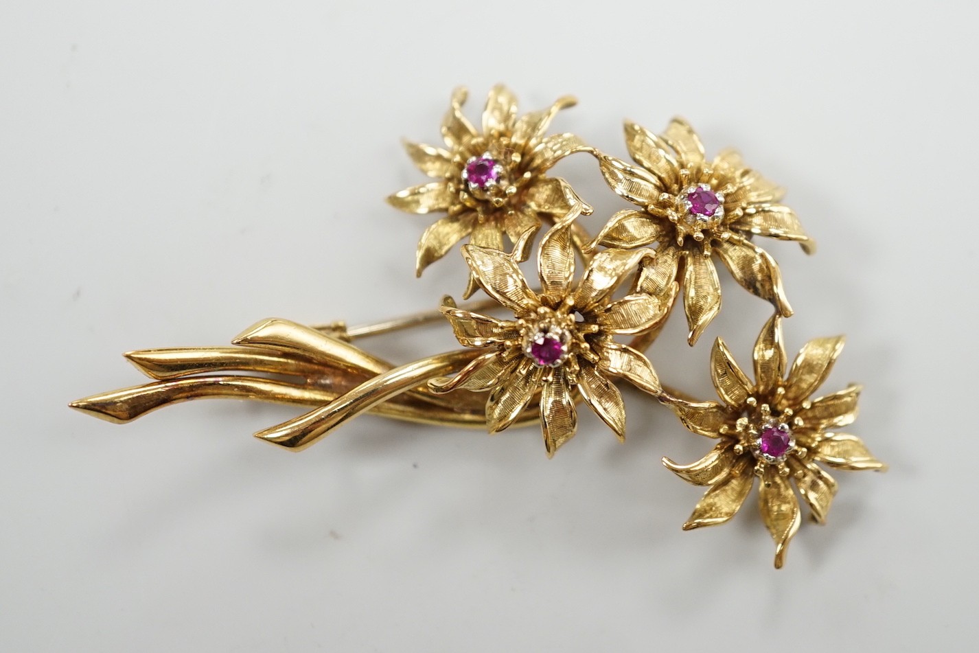 A 1960's 18ct gold and four stone ruby set floral spray brooch, 50mm